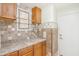 Laundry room with wood cabinets, tile backsplash, and built-in drying rack at 37307 W Oliveto Ave, Maricopa, AZ 85138