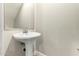 Pedestal sink and mirror in the half-bath at 1406 W Main St # 137, Mesa, AZ 85201