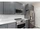 Updated kitchen boasts stainless steel appliances, white countertops, and gray cabinets at 1406 W Main St # 137, Mesa, AZ 85201