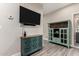 Living room with wood-look tile floors, a turquoise cabinet, and a mounted TV at 1406 W Main St # 137, Mesa, AZ 85201