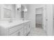 Modern white bathroom featuring a double vanity, large mirror, and marble-look tile floor at 23396 W Burton Ave, Buckeye, AZ 85326