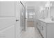 Bright bathroom with dual vanities, a glass shower, and marble tile floor at 23396 W Burton Ave, Buckeye, AZ 85326