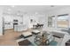 Open-concept kitchen and dining area with modern white cabinets and wood-look flooring at 23396 W Burton Ave, Buckeye, AZ 85326