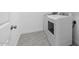 Simple laundry room with a washer, dryer, and gray tile floor at 23396 W Burton Ave, Buckeye, AZ 85326