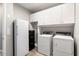 Bright laundry room with washer, dryer, and storage cabinets at 16944 W Coronado Rd, Goodyear, AZ 85395