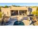 Aerial view of a kidney-shaped pool and patio area, with a large house in the background at 14129 E Barbie Ln, Scottsdale, AZ 85262