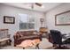 Home office with a comfortable couch, wooden desk, and large window at 18478 N Canal Dr, Surprise, AZ 85374