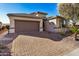 Single-story home with a two-car garage and a brick paved driveway at 18478 N Canal Dr, Surprise, AZ 85374