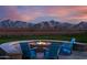 Relaxing backyard firepit with mountain views and blue Adirondack chairs at 12311 W Parkway Ln, Avondale, AZ 85323