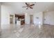 Open floor plan living area with kitchen island, tile floors, and ceiling fan at 16914 S 180Th Ave, Goodyear, AZ 85338