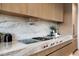 Modern kitchen detail showing cooktop, fixtures, and marble countertops at 5525 E Lincoln Dr # 124, Paradise Valley, AZ 85253