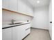 Bright laundry room with white cabinets and a stainless steel sink at 5525 E Lincoln Dr # 124, Paradise Valley, AZ 85253