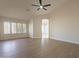 Spacious bedroom with wood-look floors, ceiling fan, and access to the bathroom at 19832 N 95Th Ave, Peoria, AZ 85382
