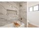 Bathroom with marble tile shower, bathtub, and recessed shelving at 19832 N 95Th Ave, Peoria, AZ 85382