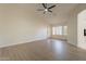 Bright bedroom with wood-look floors, ceiling fan, and access to the bathroom at 19832 N 95Th Ave, Peoria, AZ 85382