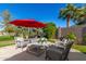 Backyard patio with seating area, umbrella, and view of golf course at 1322 W Indigo Dr, Chandler, AZ 85248