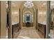 Luxurious bathroom with and vanities, marble floors, and a large chandelier at 42383 N 111Th Pl, Scottsdale, AZ 85262
