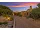Tuscan-style home with a long brick driveway at sunset at 42383 N 111Th Pl, Scottsdale, AZ 85262