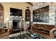 Elegant living room with stone fireplace, large screen TV, and comfortable seating at 42383 N 111Th Pl, Scottsdale, AZ 85262