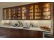 Well-equipped wet bar with glass-front cabinets and a wine cooler at 42383 N 111Th Pl, Scottsdale, AZ 85262