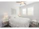 Bedroom with white bedding and wood-framed wall art at 13384 W Red Range Way, Peoria, AZ 85383