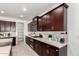 Modern kitchen with dark cabinets, granite countertops, and stainless steel appliances at 4512 W Suncup Dr, San Tan Valley, AZ 85144
