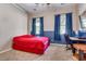 Bright bedroom with a red bed, blue curtains, and a workspace at 23724 S 126Th St, Chandler, AZ 85249