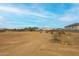 Empty lot with desert landscape and distant homes at 14930 W El Cortez Pl, Surprise, AZ 85387