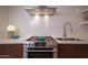 Modern kitchen detail showing gas cooktop, double sink, and white tile backsplash at 6814 E Monterey Way, Scottsdale, AZ 85251