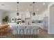 Bright, spacious kitchen featuring white cabinetry, an island with seating, and stainless steel appliances at 4550 N 192Nd Dr, Litchfield Park, AZ 85340