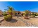 House with a large front yard, palm trees and stone pathway at 19326 N Tallowood Way, Surprise, AZ 85387