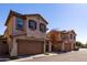 Tan two-story townhouses with brown garage doors and dark shutters at 4636 E Tierra Buena Ln, Phoenix, AZ 85032