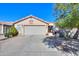 Tan single story home with a two-car garage and desert landscaping at 2414 E Antigua Dr, Casa Grande, AZ 85194