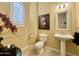 Elegant powder room with a pedestal sink, toilet, and decorative artwork at 2222 N Val Vista Dr # 3, Mesa, AZ 85213
