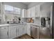 Updated kitchen featuring white cabinets, stainless steel appliances, and tile backsplash at 158 W Commerce Ct, Gilbert, AZ 85233