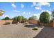 Landscaped backyard with gravel, bushes, and trees at 21613 N 261St Ave, Buckeye, AZ 85396