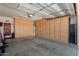 Garage with built-in wooden cabinets and overhead storage at 21613 N 261St Ave, Buckeye, AZ 85396