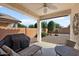 Covered patio with seating area and built-in grill at 21613 N 261St Ave, Buckeye, AZ 85396