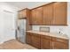 Modern kitchen with stainless steel refrigerator and wood cabinets at 24741 N 175Th Dr, Surprise, AZ 85387