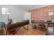 Bright home office features two desks, brick accent wall, and ample natural light at 955 S Henry Ln, Gilbert, AZ 85296
