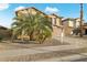 Two-story house with tan exterior, large garage, and palm trees in front at 16800 W Mesquite Dr, Goodyear, AZ 85338