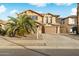 Two-story house with tan exterior, large garage, and palm trees in front at 16800 W Mesquite Dr, Goodyear, AZ 85338