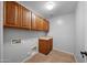 Laundry room with wood cabinets and tile flooring at 16800 W Mesquite Dr, Goodyear, AZ 85338