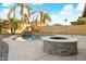 Kidney-shaped pool with a fire pit and rock waterfall feature at 16800 W Mesquite Dr, Goodyear, AZ 85338
