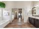 Bathroom boasts a soaking tub, double vanity, and wood flooring at 10034 E Pantera Ave, Mesa, AZ 85212