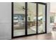 View through sliding doors to a backyard patio with an outdoor kitchen and seating area at 2677 E Queen Creek Rd, Gilbert, AZ 85297