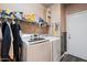 Laundry room with washer, dryer, and ample storage shelving at 10468 W Palm Ln, Avondale, AZ 85392