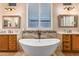 Bathroom features a luxurious soaking tub, double vanities, and large mirrors at 41619 N River Bend Rd, Anthem, AZ 85086