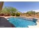 Large swimming pool with a waterfall feature in a desert landscape at 41619 N River Bend Rd, Anthem, AZ 85086