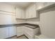 Bright laundry room with white cabinets, granite countertops and bench at 24005 N 45Th Dr, Glendale, AZ 85310